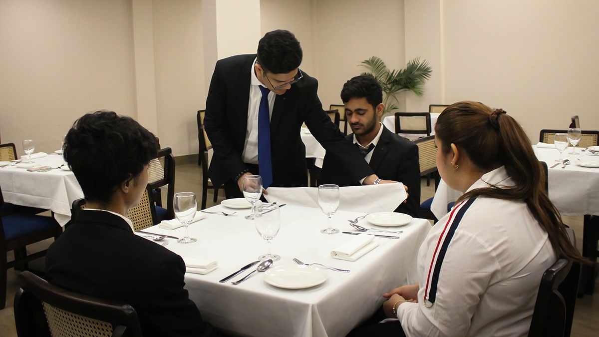 Students in hospitality training — table service