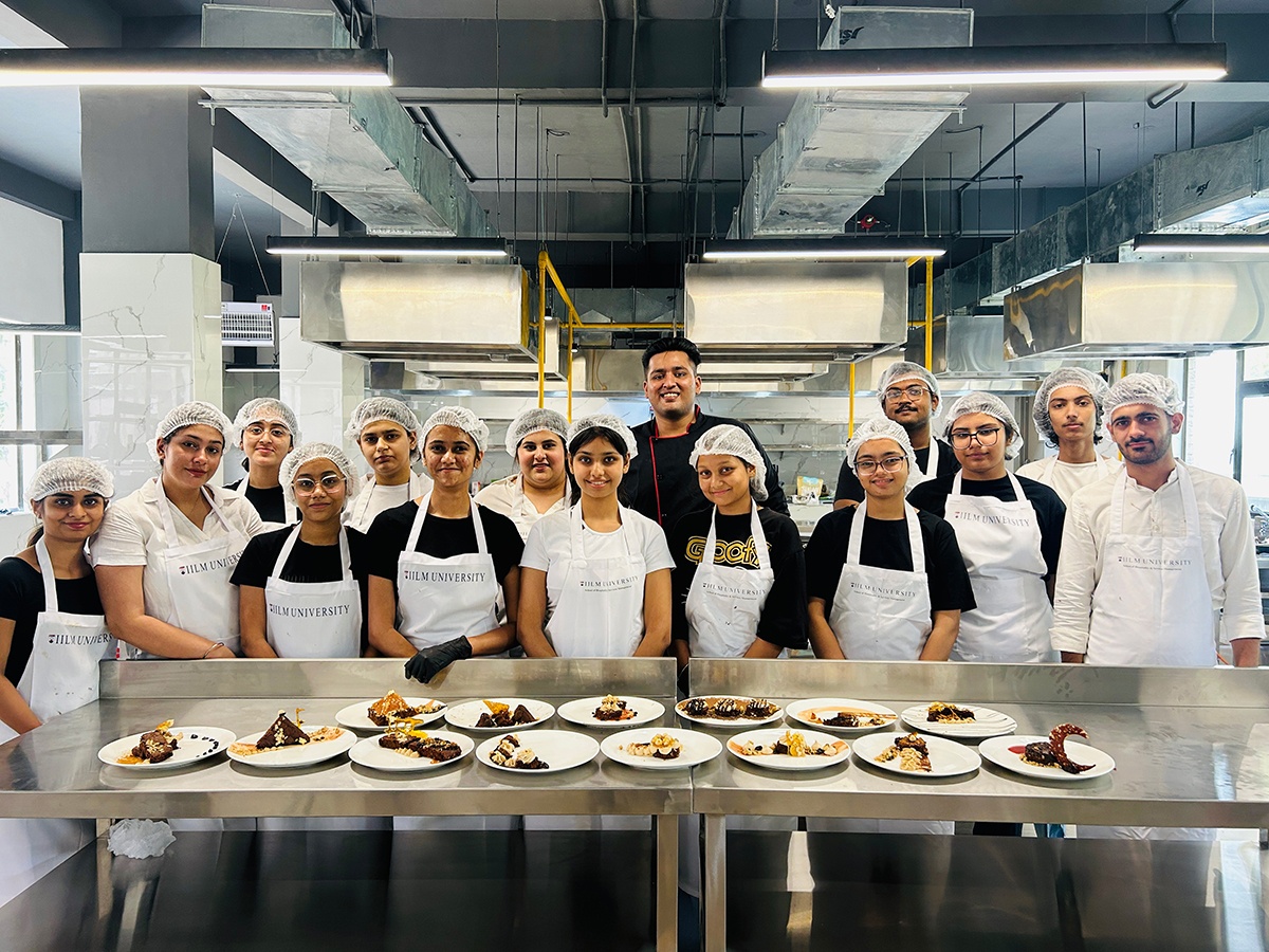 Students with plated dishes in kitchen lab